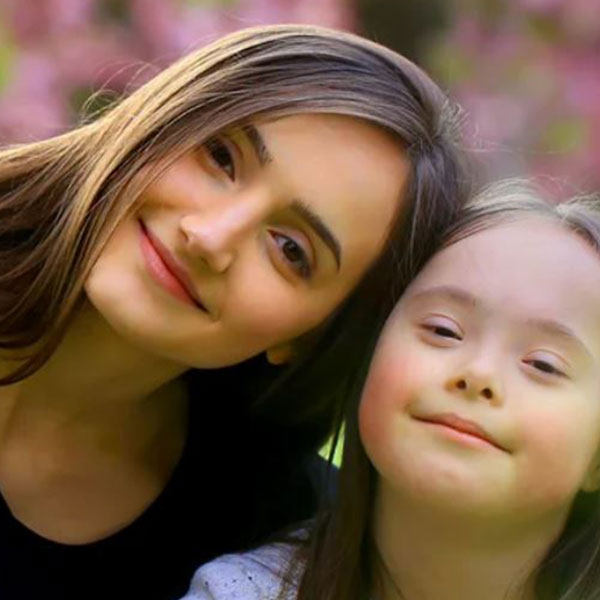 Two girls eating an apple. 